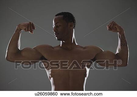Physically fit man flexing his triceps View Large Photo Image Stock Image - Physically fit man flexing his triceps. Fotosearch