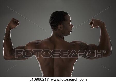 Physically fit man flexing his triceps View Large Photo Image Stock Photo - Physically fit man flexing his triceps. Fotosearch
