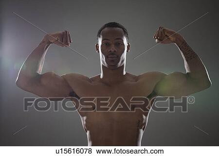 Physically fit man flexing his triceps View Large Photo Image Stock Photo - Physically fit man flexing his triceps. Fotosearch