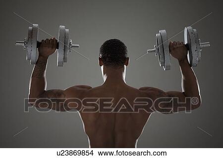 Physically fit man lifting dumbbells View Large Photo Image Picture - Physically fit man lifting dumbbells. Fotosearch