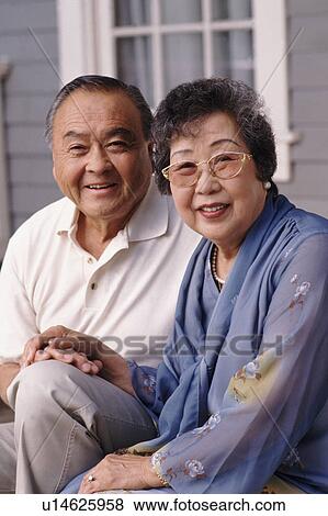 Stock Photo - Portrait of a couple in front of their house. Fotosearch