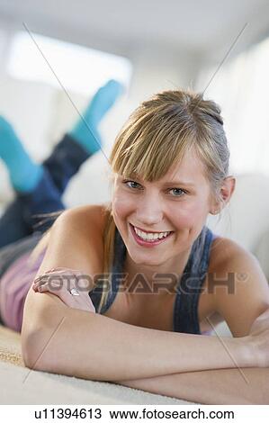 Portrait of a young woman lying on floor View Large Photo Image Stock Image - Portrait of a young woman lying on floor. Fotosearch