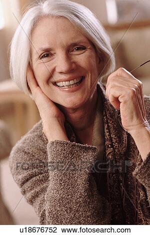 Portrait of an elderly woman holding her reading glasses View Large Photo Image Stock Image - Portrait of an elderly woman holding her reading glasses. Fotosearch