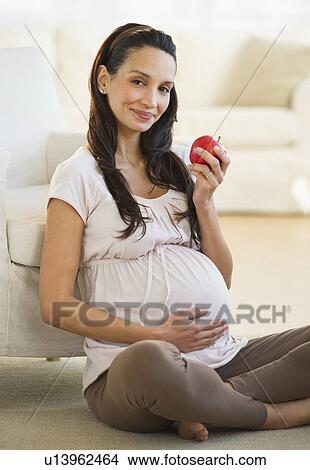 Pregnant woman eating an apple View Large Photo Image Picture - Pregnant woman eating an apple. Fotosearch