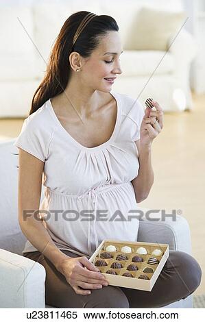 Stock Photography - Pregnant woman eating chocolate. Fotosearch