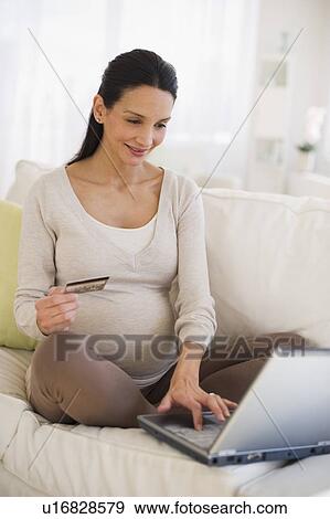 Stock Photo - Pregnant woman shopping on-line. Fotosearch