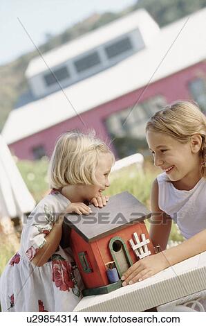 Siblings playing outdoors with a toy house View Large Photo Image Picture - Siblings playing outdoors with a toy house. Fotosearch