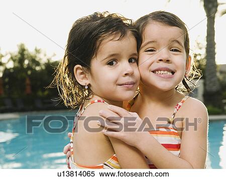 Sister embracing beside pool View Large Photo Image Stock Photography - Sister embracing beside pool. Fotosearch