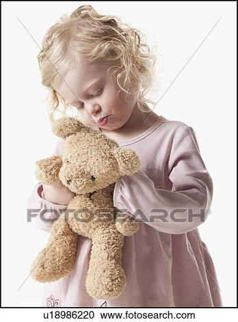 Tired young girl holding teddy bear View Large Photo Image Stock Image - Tired young girl holding teddy bear. Fotosearch