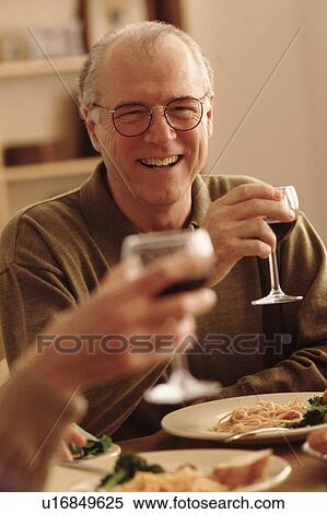 Stock Photography - Toasting with wine at the dinner table. Fotosearch