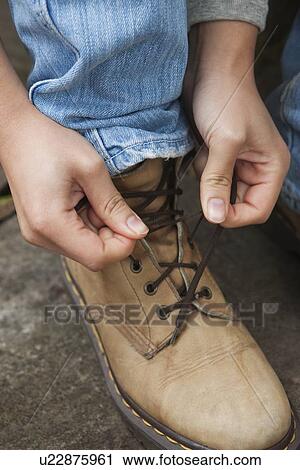 Stock Image - Tying up boot laces. Fotosearch