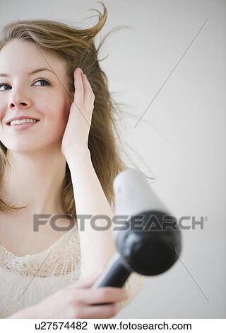 Woman blow drying hair View Large Photo Image Stock Image - Woman blow drying hair. Fotosearch