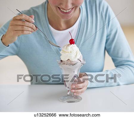 Woman eating ice cream sundae View Large Photo Image Stock Photograph - Woman eating ice cream sundae. Fotosearch
