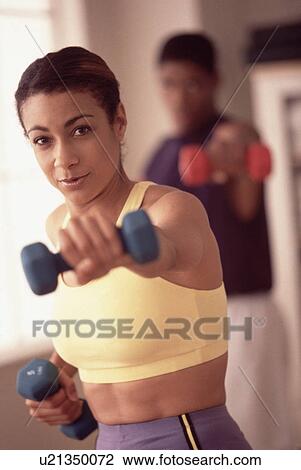 Woman exercising with dumbbells View Large Photo Image Stock Image - Woman exercising with dumbbells. Fotosearch