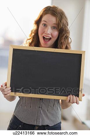 Stock Photograph - Woman holding a blank chalkboard. Fotosearch
