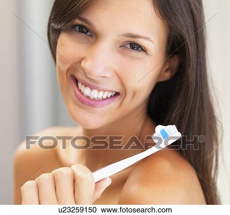 Stock Image - Woman holding a toothbrush. Fotosearch