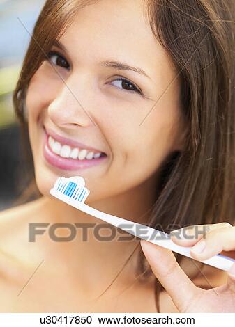 Stock Image - Woman holding a toothbrush. Fotosearch
