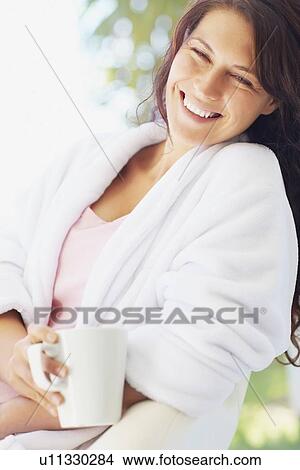 Woman in bathrobe drinking coffee View Large Photo Image Picture - Woman in bathrobe drinking coffee. Fotosearch