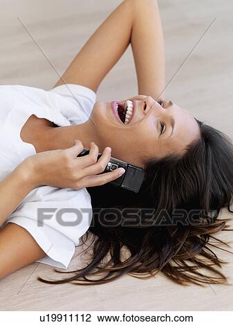 Woman laughing while talking on cellular phone View Large Photo Image Stock Image - Woman laughing while talking on cellular phone. Fotosearch