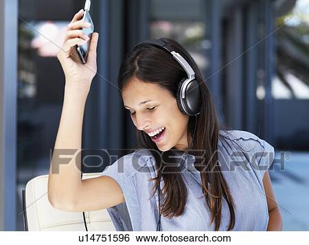 Woman listening to music on headphones View Large Photo Image Stock Photograph - Woman listening to music on headphones. Fotosearch