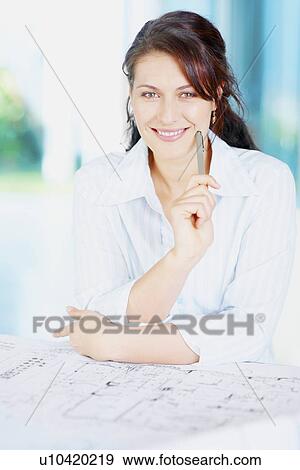 Stock Photo - Woman looking at blueprints. Fotosearch