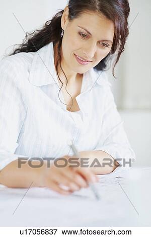 Stock Photo - Woman looking at blueprints. Fotosearch