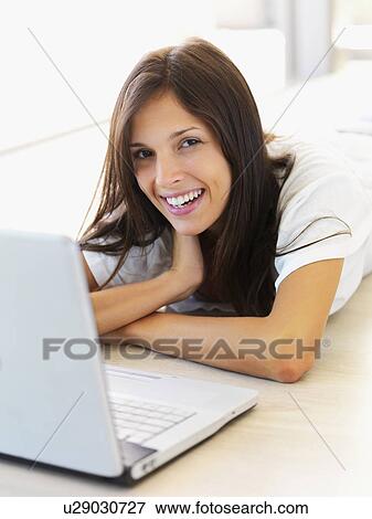 Stock Photo - Woman looking at laptop. Fotosearch