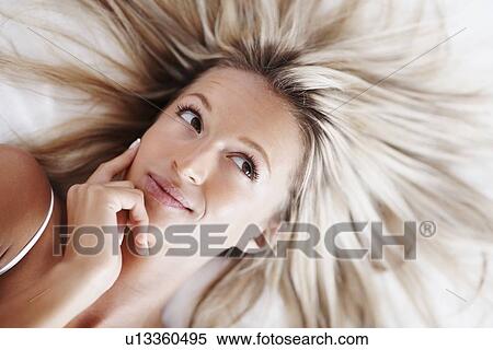 Stock Photography - Woman lying on bed. Fotosearch