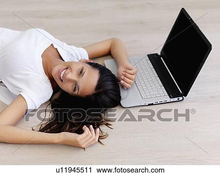 Stock Image - Woman relaxing on floor. Fotosearch