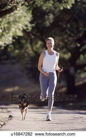 Stock Image - Woman running with her dog. Fotosearch