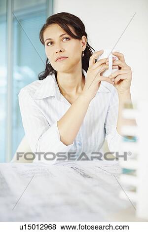 Stock Photo - Woman sitting at desk. Fotosearch