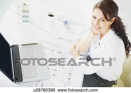Stock Photo - Woman sitting at desk. Fotosearch