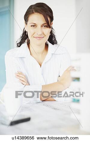 Stock Photograph - Woman sitting at desk. Fotosearch