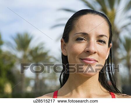 Stock Photo - Woman standing in front of palm trees. Fotosearch