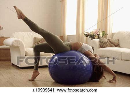 Stock Image - Woman stretching on an exercise ball. Fotosearch