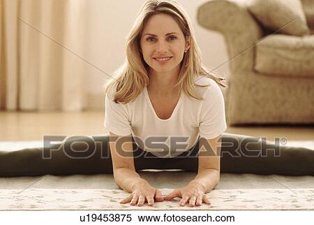 Woman stretching on the floor View Large Photo Image Stock Photography - Woman stretching on the floor. Fotosearch