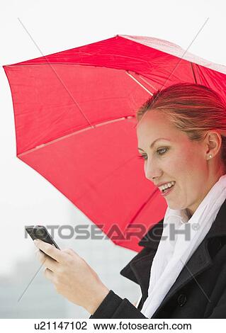 Woman texting on a rainy day View Large Photo Image Stock Image - Woman texting on a rainy day. Fotosearch