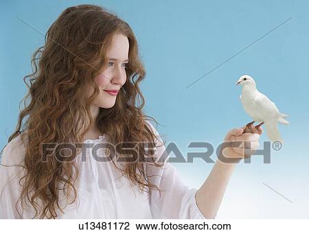 Woman with a dove perched on her hand View Large Photo Image Stock Image - Woman with a dove perched on her hand. Fotosearch