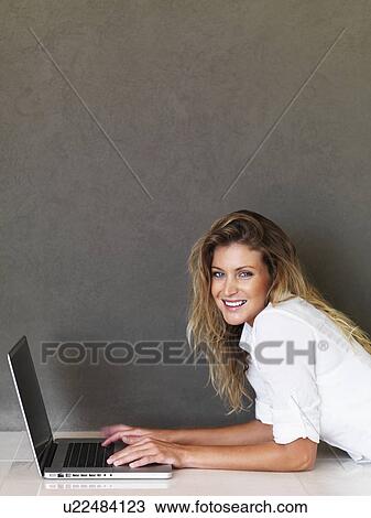 Stock Image - Woman working on laptop. Fotosearch