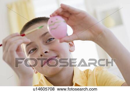 Young boy decorating an Easter egg View Large Photo Image Stock Photo - Young boy decorating an Easter egg. Fotosearch