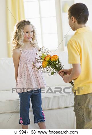 Stock Photo - Young boy giving flowers to young girl. Fotosearch
