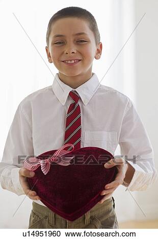 Stock Image - Young boy holding a box of chocolates. Fotosearch