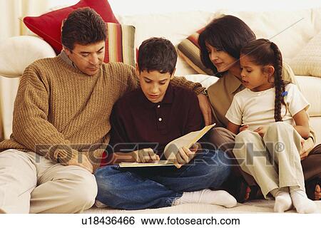 Stock Photograph - Young boy reading to his family. Fotosearch