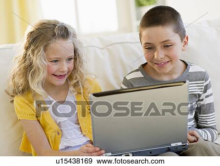 Young children looking at laptop View Large Photo Image Stock Photo - Young children looking at laptop. Fotosearch
