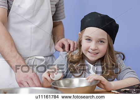 Picture - Young girl cracking an egg. Fotosearch