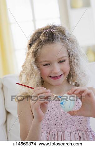 Young girl decorating an Easter egg View Large Photo Image Picture - Young girl decorating an Easter egg. Fotosearch
