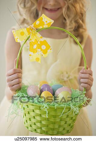 Young girl holding a basket of Easter eggs View Large Photo Image Stock Photography - Young girl holding a basket of Easter eggs. Fotosearch
