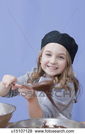Stock Photo - Young girl holding a mixing spoon. Fotosearch