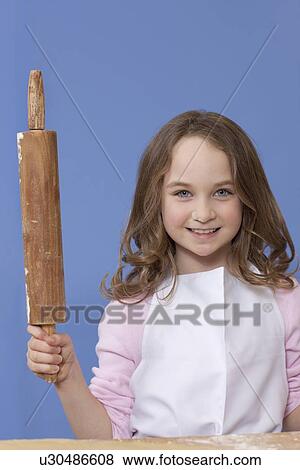 Young girl holding a rolling pin View Large Photo Image Stock Photo - Young girl holding a rolling pin. Fotosearch