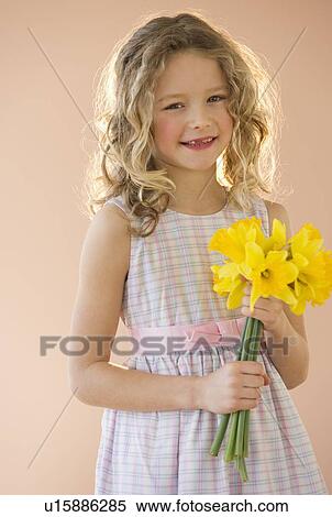 Stock Photography - Young girl holding daffodils. Fotosearch